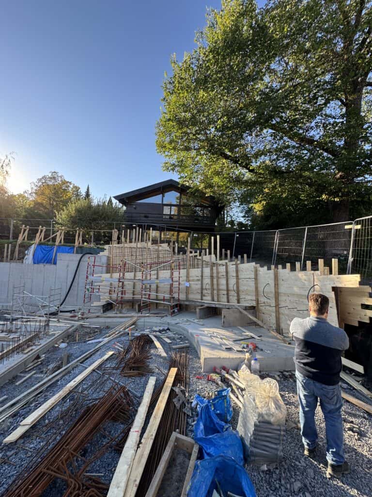 Betongkonstruksjon av hage med treverk og støttemurer for byggeprosjekt.