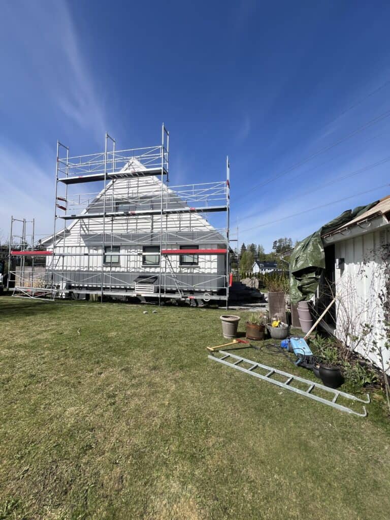 Rehab printtr den lokale av huset med byggeskje og scaffolding for oppussing eller malingsarbeid.