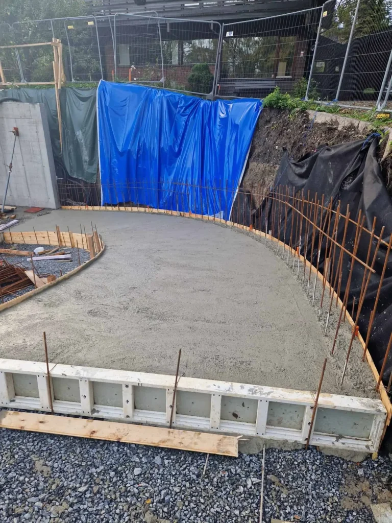 Betongarbeid under byggeprosjekt, oppfylling av fundament med armering. Byggproffene tilbyr profesjonell bygge- og betongarbeid.