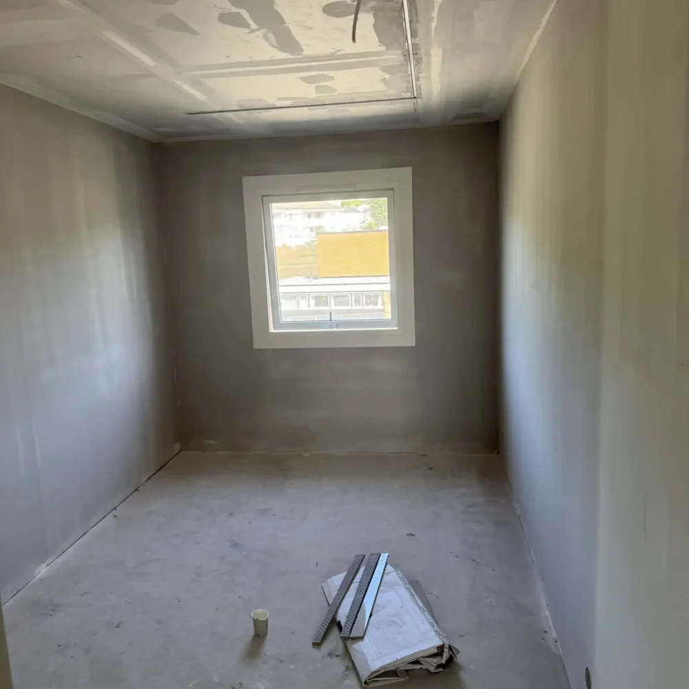 Nybygd rom under oppussing med nytt vindu og ferdigstillede vegger. Klar for maling eller gulvlegging.