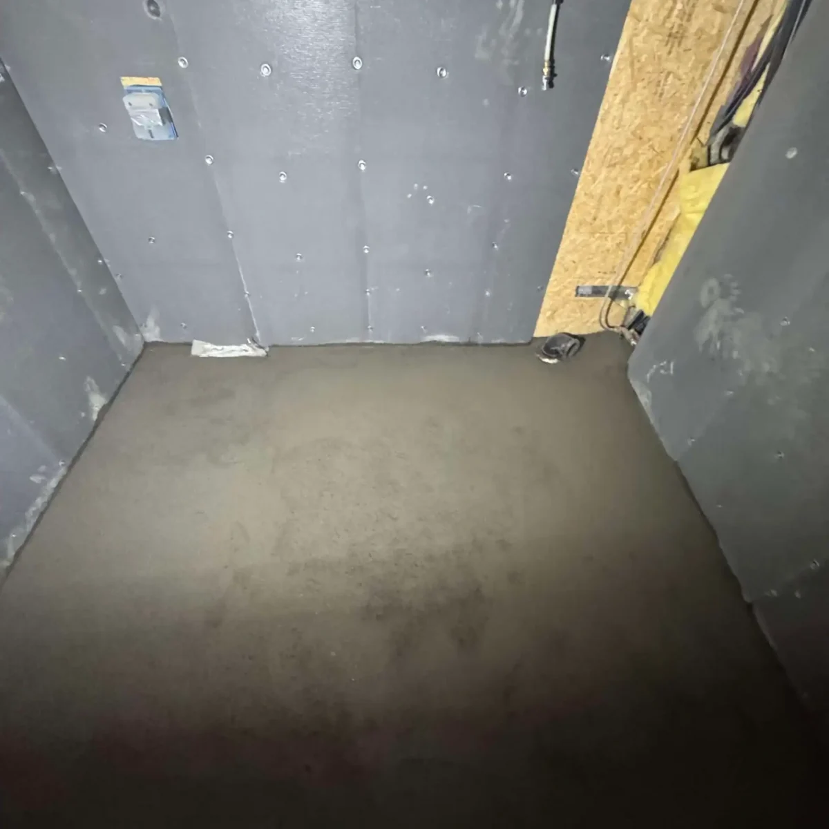 Ferdigkjørt betonggulv i byggeprosess, innvendig rom med råmaterialer og konstruksjonsarbeid.