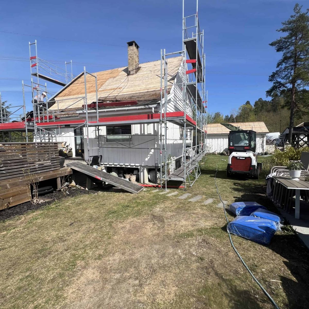 Byggproffene - Husoppussing og Takarbeid under oppføring med sikkerhetsplattform. Fremdrift i byggeprosjekt, eksperthåndverk.