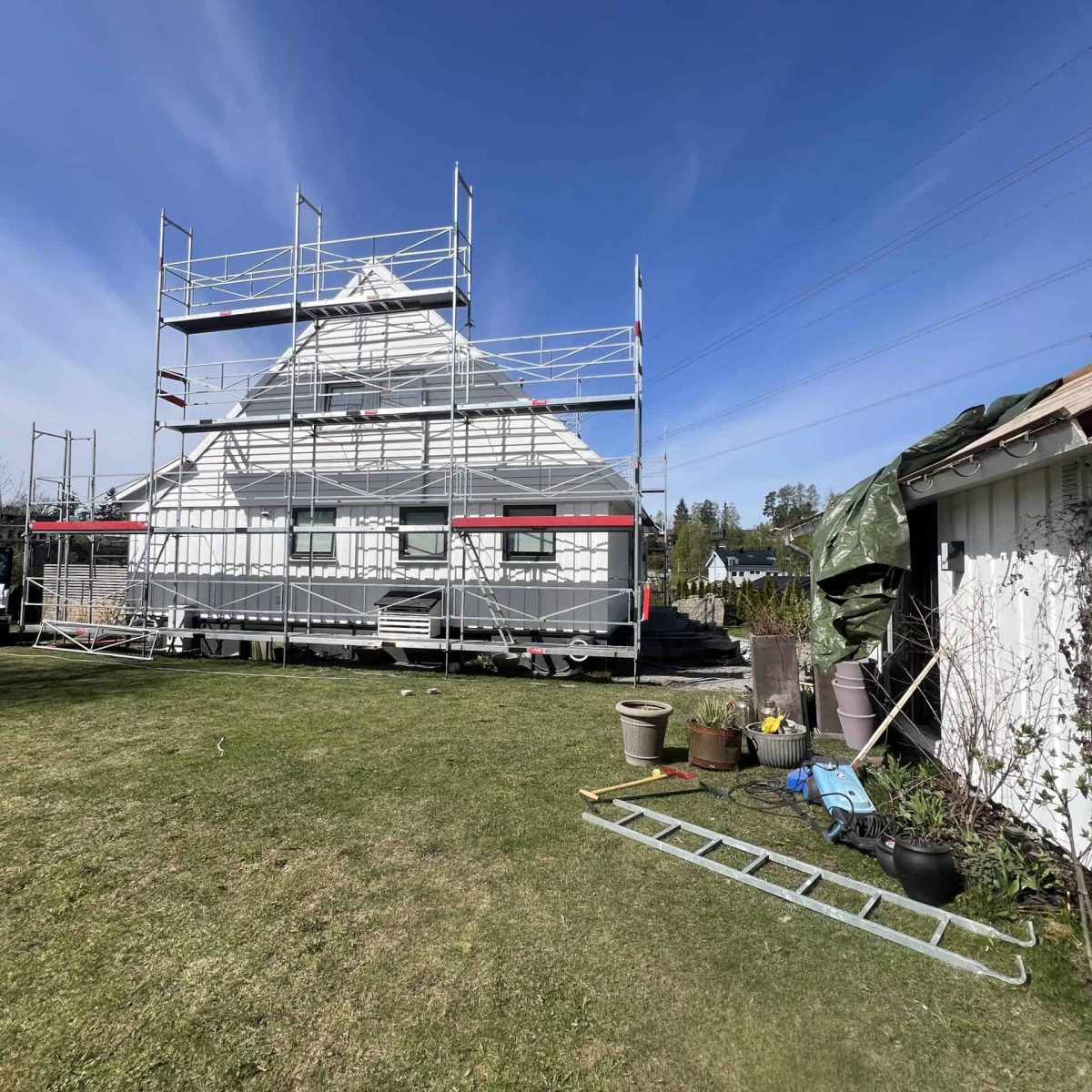 Rehab printtr den lokale av huset med byggeskje og scaffolding for oppussing eller malingsarbeid.