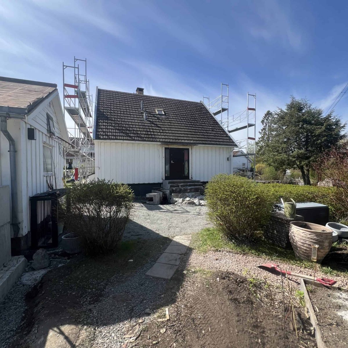 Hage- og uteromsprosjekt under oppføring med byggearbeid, scaffolding og ny terrasse.