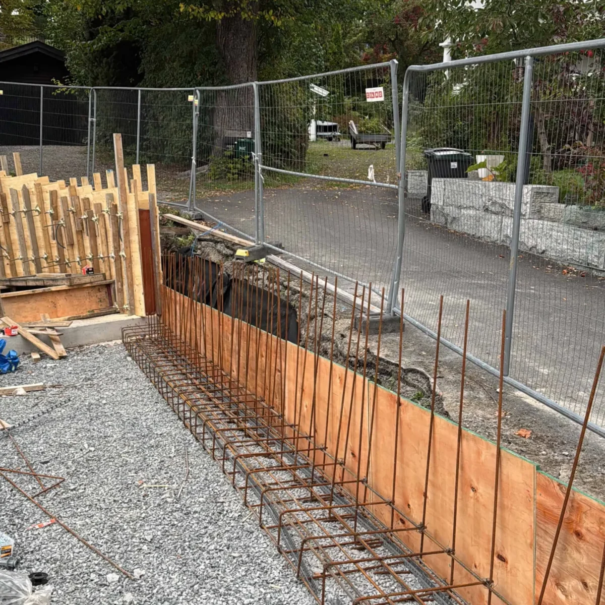 Byggproffene, byggeplass med armeringsjern og oppheting, klar for betongstøp. Professionell byggeprosess med fokus på kvalitet og sikkerhet.